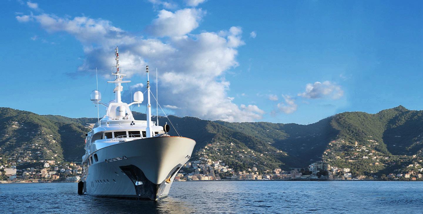 Yacht in a bay connected with marine satellite internet with Viasat's Cobham sailor antenna.
